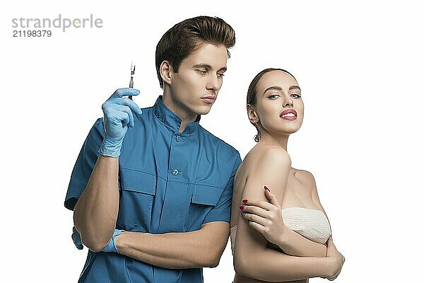 Plastic surgeon holding a syringe with his female beautiful patient isolated cropped view on white background