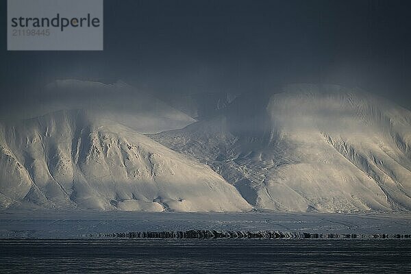 Snow-covered mountains  veil of clouds  Woodfjord  Svalbard and Jan Mayen  Norway  Europe