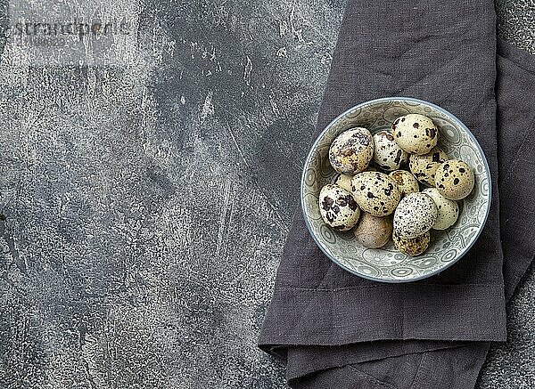 Food  Food  Quail eegs en bowl  gray background. Top view  copy space