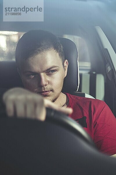 Portrait of an handsome guy driving his car