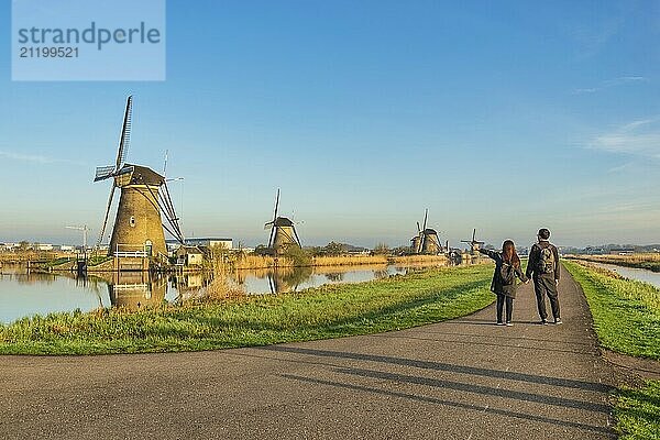 Niederländische Windmühlenlandschaft in Kinderdijk Dorf Niederlande mit Liebespaar zu Fuß