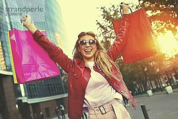 Shopping woman walking outside at street holding shopping bags. Shopper smiling happy walking the street after shopping