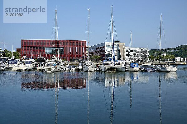 Modern buildings in red and white and boats in the harbour reflected in the calm water  Sandnes  Fylke Rogaland  Norway  Europe