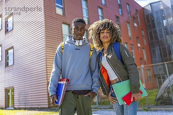 Cool multiracial students smiling at camera outside the university in a sunny day of autumn