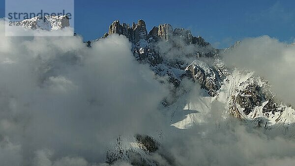 Fliegen durch schöne weiße flauschige Wolken zwischen hohen felsigen Bergen. Dolomiten Alpen Berge  Italien  Europa