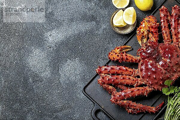 Food  Food  Red king crab on gray background. King crab  lemon and cilantro  top view