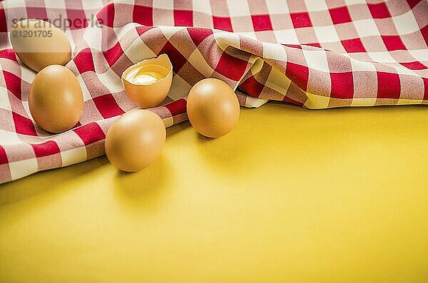 Beautiful fresh brown chicken eggs on yellow background with copy space