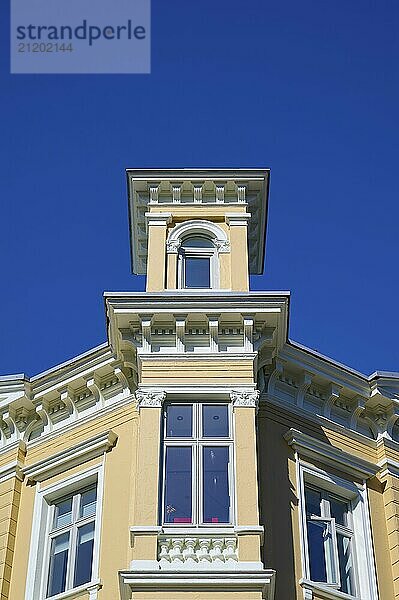 Historic yellow building with several windows in front of a bright blue sky  Bergen  Vestland  Norway  Europe