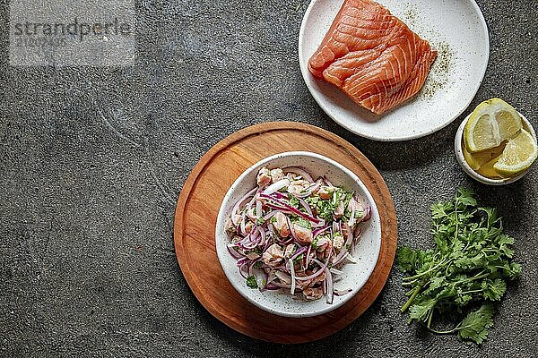 Food  Food  CHILEAN SALMON CEVICHE. Fresh raw salmon marinaded with purple onion  coriander in lemon juice. Sebiche and ingredientes on gray background. Top view