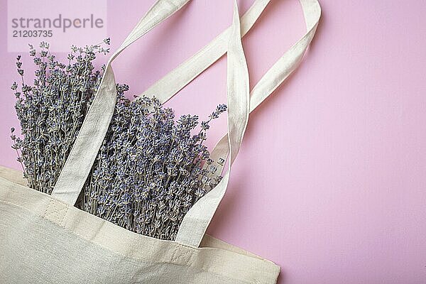 Lavendel Blumenstrauß in beige Öko Leinen Shopper Tasche auf lila Hintergrund von oben. Romantische Frühling oder Sommer girly femininen Hintergrund  Platz für Text  Lebensmittel Fotografie  food photography  food photography