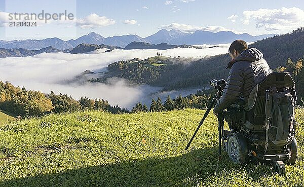 Man on wheelchair taking photos of beautiful landscape