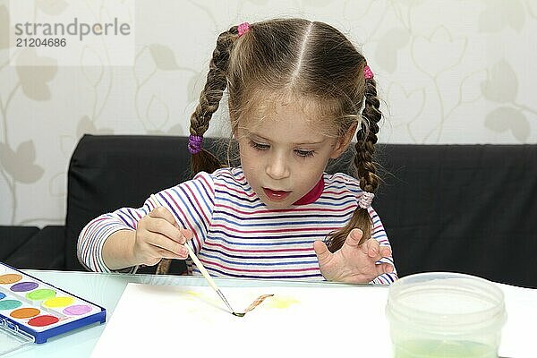 Little girl draws paints at home