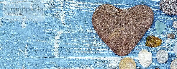 Sea pebbles and seashells on the table. A pyramid of sea stones on a blue background