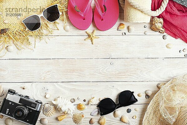 Camera straw hat sunglasses flip flops on white wooden background