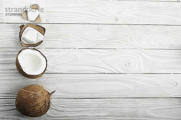 Flat lay background of coconut  coconut shell and meat pieces on white wooden table