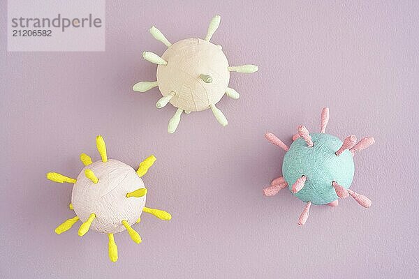 Hand crafted models of corona virus covid 19 against pink background