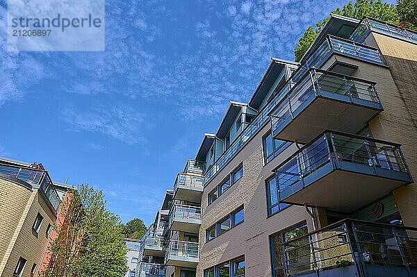 Modern residential building with several balconies and glass railings under a blue sky with clouds in a cityscape  Bergen  Vestland  Norway  Europe