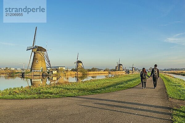 Niederländische Windmühlenlandschaft in Kinderdijk Dorf Niederlande mit Liebespaar zu Fuß