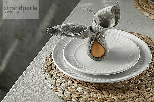 Food  Food  Festive Easter table setting. Funny Easter bunny made of egg and linen napkin on plate. Gray background