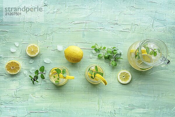 Limonade mit Minze. Zitronenwasser Getränk mit Eis. Zwei Gläser und ein Krug auf einem blauen Hintergrund  Overhead Flachbildaufnahme. Detox Getränk. Frische hausgemachte Cocktails  Food Fotografie