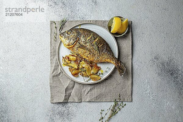 Food  Grilled sea bream or dorada on gray plate. Gray background