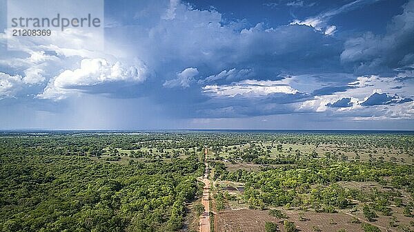 Aerial view of Transpantaneira dirt road with dramatic sky and rain crossing the typical landscape in North Pantanal Wetlands  Mato Grosso  Brazil  South America