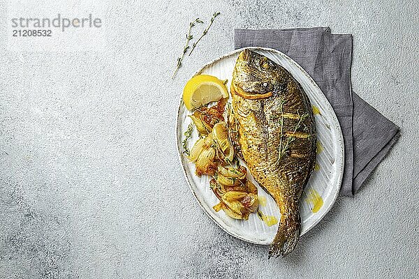 Food  Food  Grilled sea bream or dorada on gray plate. Gray background