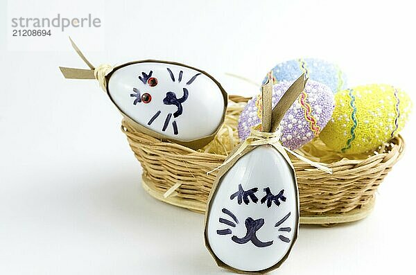 Happy easter bunny egg and eggs colored eggs in a basket isolated on a trendy white background. Minimal easter concept. Easter card with copy space for text