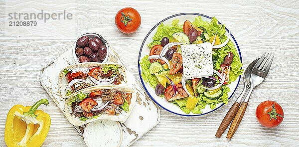 Traditionelles griechisches Essen: Griechischer Salat  Gyros mit Fleisch und Gemüse  Tzatziki Sauce  Oliven auf weißem rustikalen Holztisch Hintergrund von oben. Griechische Küche  Lebensmittel Fotografie