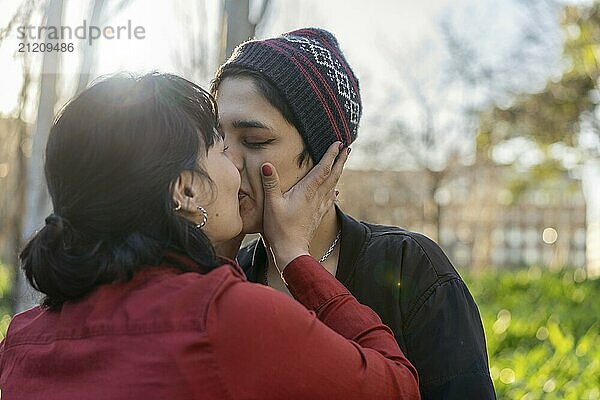 Young woman planting a sweet kiss on her girlfriend's lips