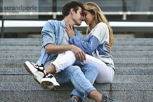 Happy to spending time together. Young beautiful couple outdoor fashion portrait. Attractive boy and girl hugging and kissing