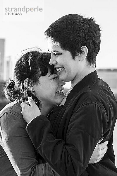 Black and white portrait of a couple of women embracing and laughing together