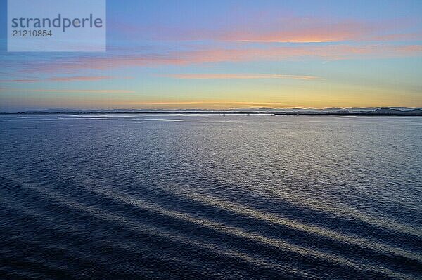 Tranquil seascape at sunrise with gentle waves and pastel-coloured sky  Bergen  Vestland  Norway  Europe