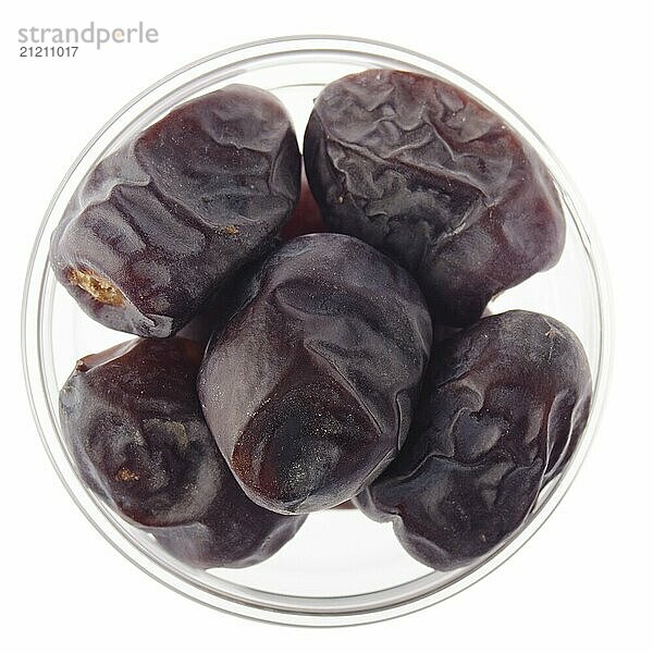 Dried dates in glass bowl isolated on white background flat lay closeup view