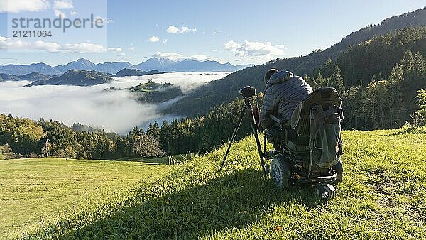 Man on wheelchair taking photos of beautiful landscape