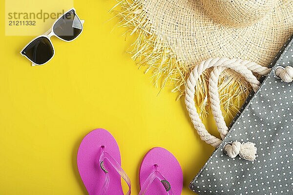 Flip flops straw hat sunglesses and beach bag on yellow background vacation travel planning mockup