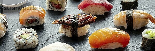 Sushi Panorama. Nigiri mit Aal  Lachs  Garnelen auf schwarzem Hintergrund  Japanisches Essen auf einem Teller in einem asiatischen Restaurant  Food Fotografie