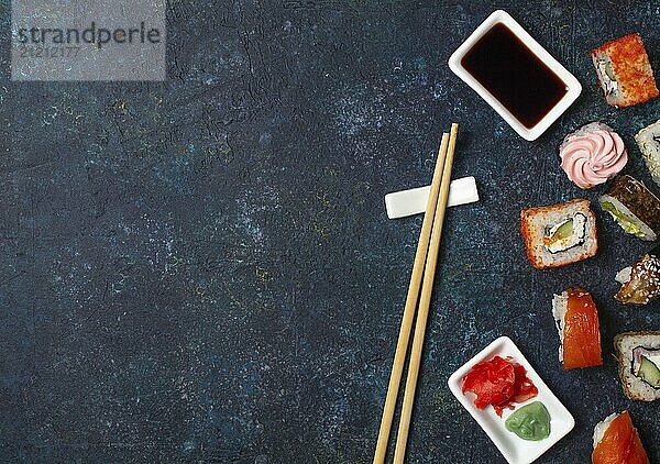 Food  Sushi roll set with chopstick and soy sauce on blue background. Copy space  top view