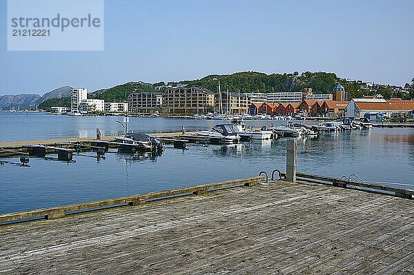 A harbour with a wooden jetty and several boats  surrounded by buildings and mountains under a clear sky  peaceful atmosphere  Sandnes  Fylke Rogaland  Norway  Europe