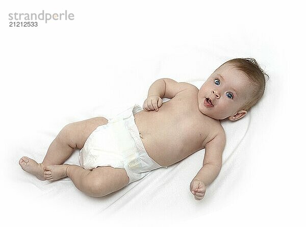 Baby girl in diaper lying on white sheet