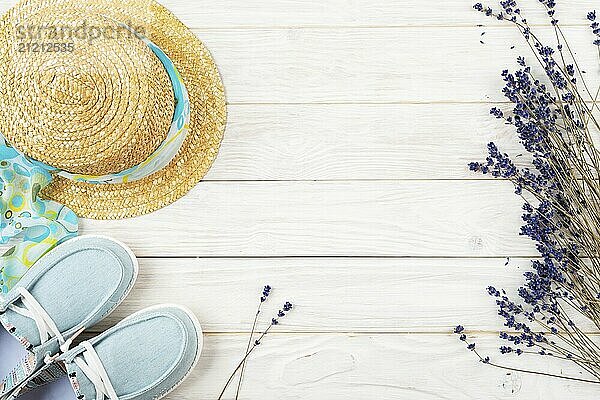 Straw hat  lavender flovers and fabric moccasins on white planks vacation planning background flat lay with copy-space