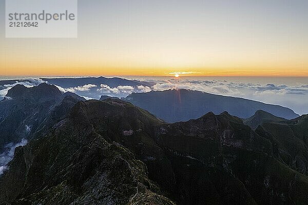 Aerial drone view of mountains over clouds near Pico Ruivo on sunset. Madeira island  Portugal  Europe