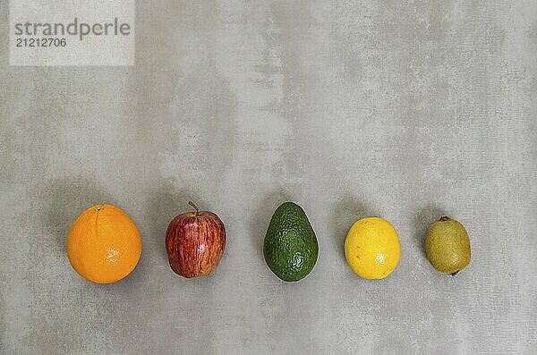 Great concept of healthy eating  various fruits on gray background  polished concrete. Orange  apple  kiwi  lemon