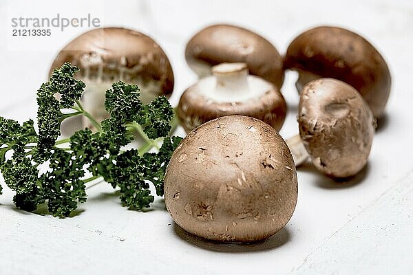 Brown champignon with parsley on a white background  close up