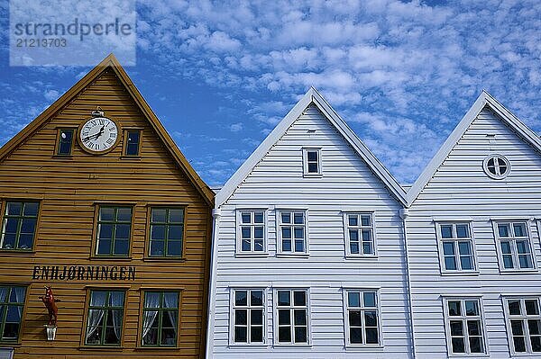 Traditional wooden houses under a blue sky with pitched roofs and multiple windows in a sunny old town  Bryggen  Bergen  Vestland  Norway  Europe