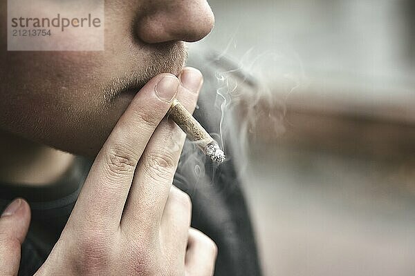 Guy smokes a cigarette outside  portrait  close-up  smoke