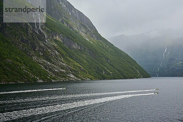 Two speedboats with groups of people travelling fast in the Geiranger Fjord  white waves are coming up behind them  Geiranger  Geiranger Fjord  Stranda  Romsdal  Norway  Europe