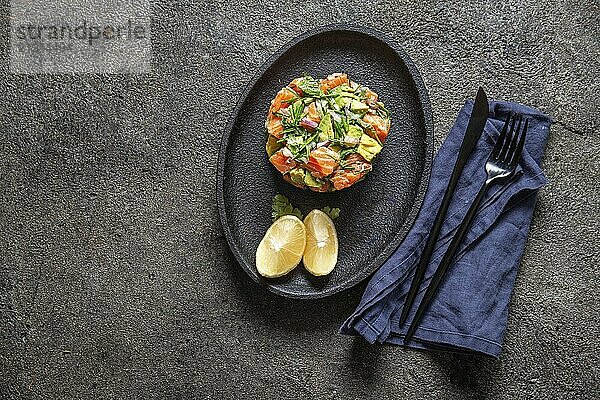 Food  Food  PERUVIAN NIKKEI FOOD. Salmon avocado ceviche on black plate  black background top view