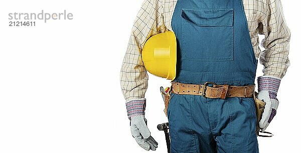 Middle aged contractor in overalls with tool belt holds yellow hard hat in his hands on white background