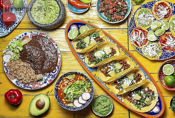 Food Photography  Mexican festive food for independence day  independencia chiles en nogada  tacos al pastor  chalupas pozole  tamales  chicken with mole poblano sauce. Yellow background